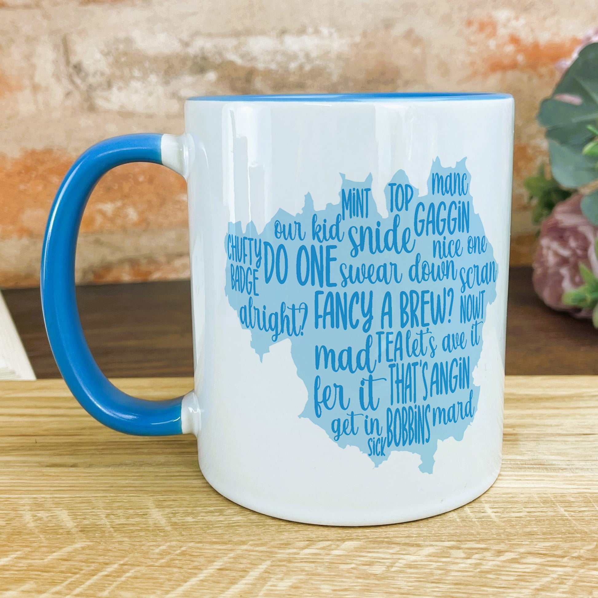 a blue and white mug sitting on top of a wooden table