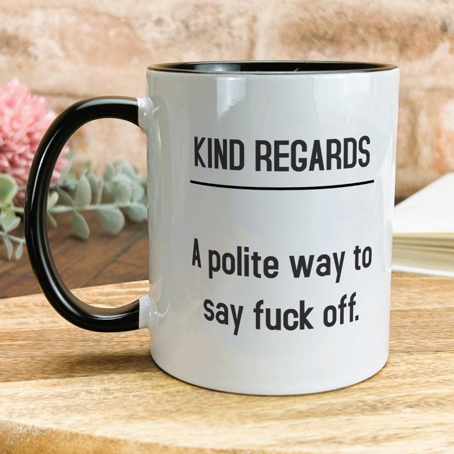 a white and black coffee mug sitting on top of a wooden table