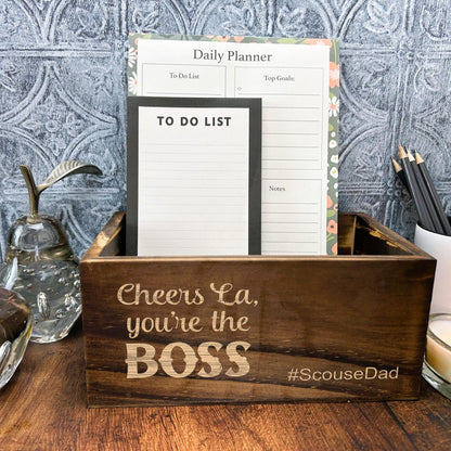 a wooden box with a notepad and a candle