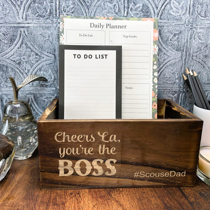 a wooden box with a notepad and a candle