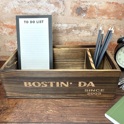 a desk with a clock, notepad and pen holder