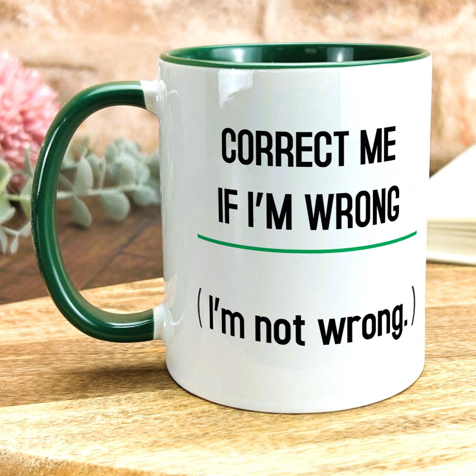 a green and white coffee mug sitting on top of a wooden table