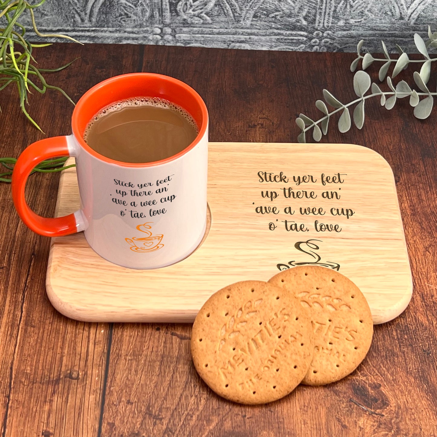 A wooden tray with a mug and two cookies on it, placed on a wooden surface.
