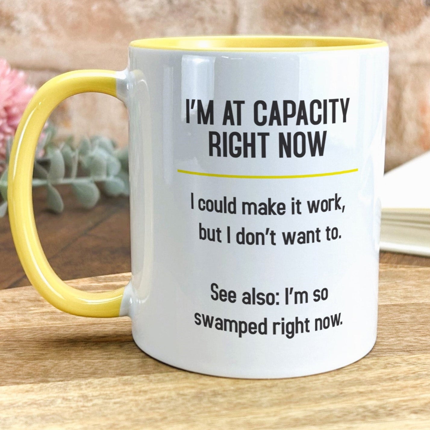 a yellow and white coffee mug sitting on top of a wooden table