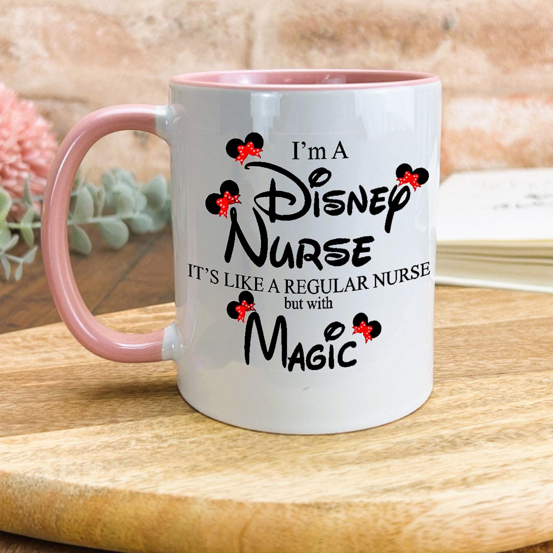 a pink and white coffee mug sitting on top of a wooden table