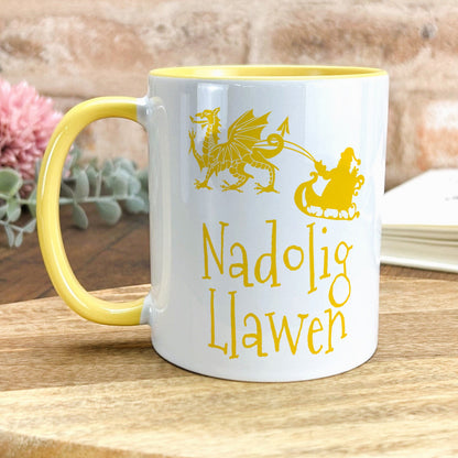 a yellow and white coffee mug sitting on top of a wooden table