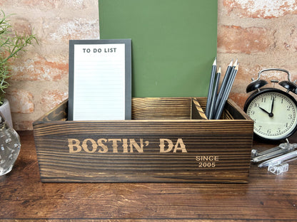 a desk with a clock, notepad and pen holder