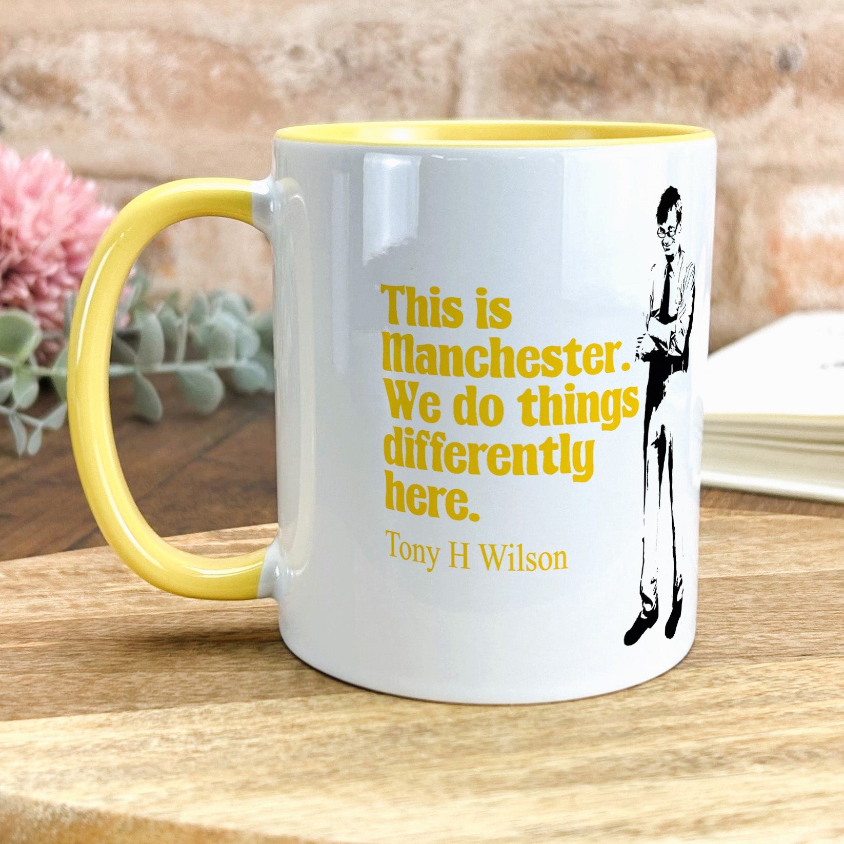 a yellow and white coffee mug sitting on top of a wooden table