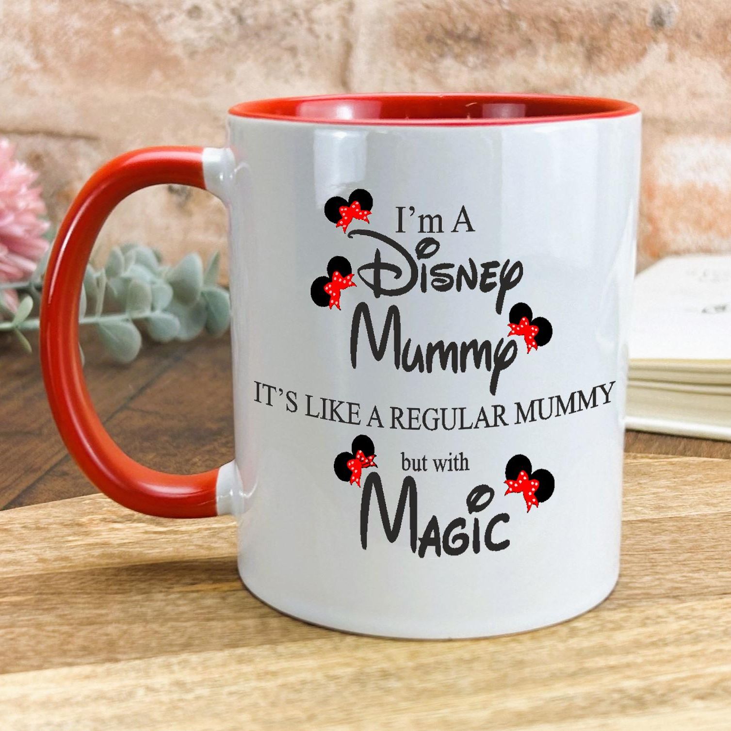 a red and white coffee mug sitting on top of a wooden table