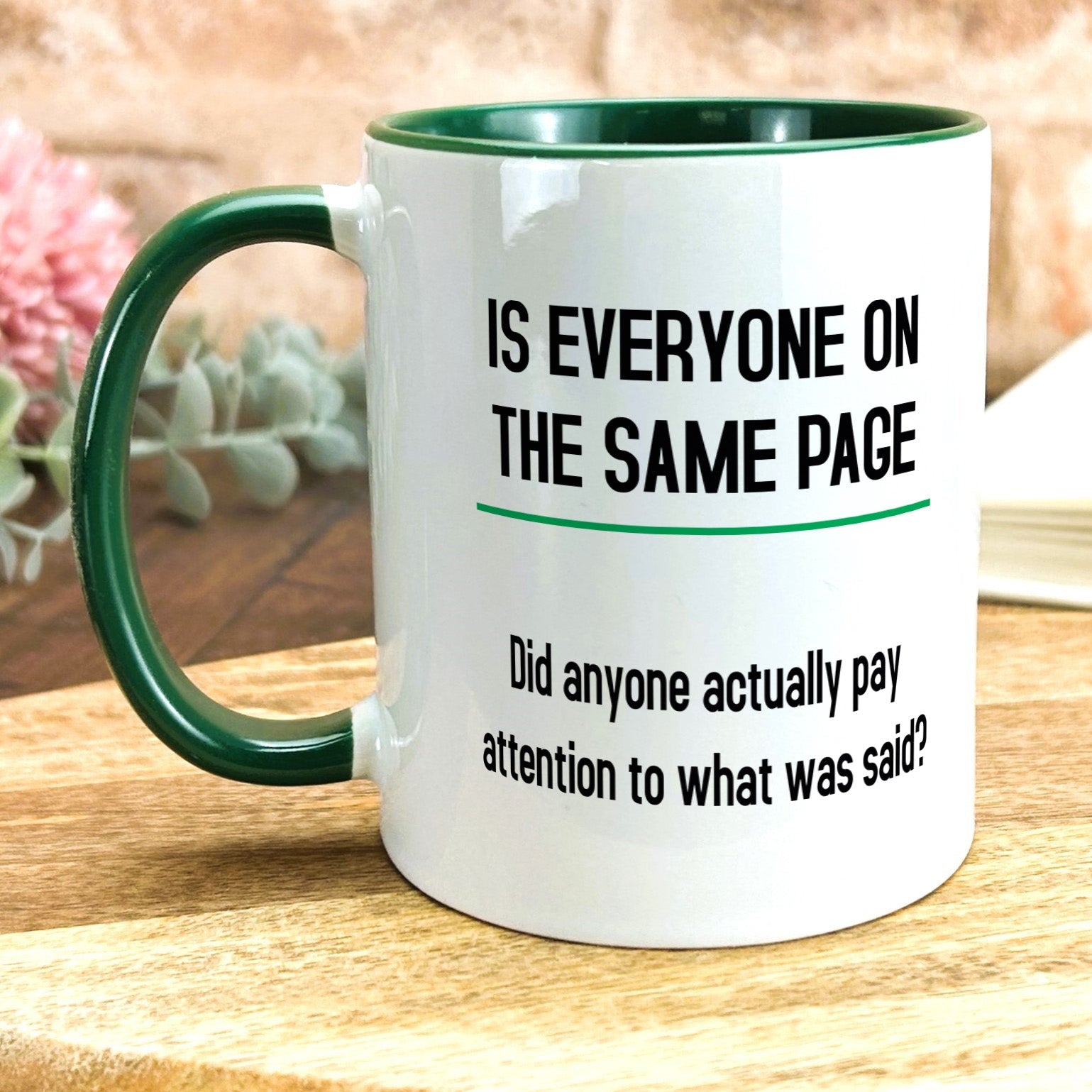 a green and white coffee mug sitting on top of a wooden table