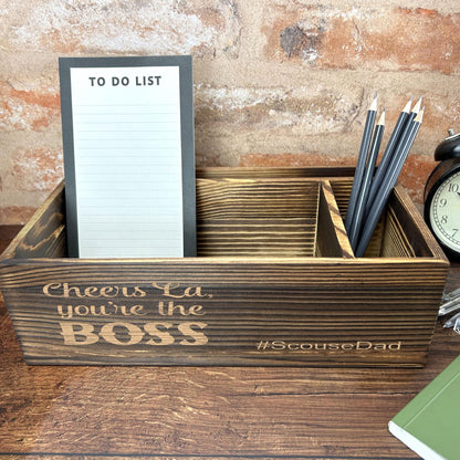 a desk with a clock, notepad and pen holder