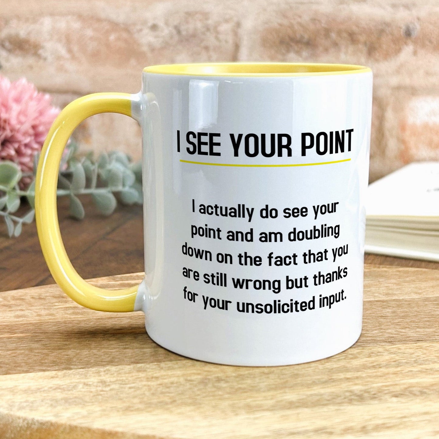 a yellow and white coffee mug sitting on top of a wooden table