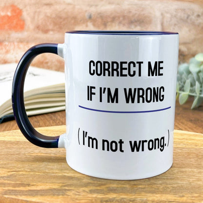 a black and white coffee mug sitting on top of a wooden table