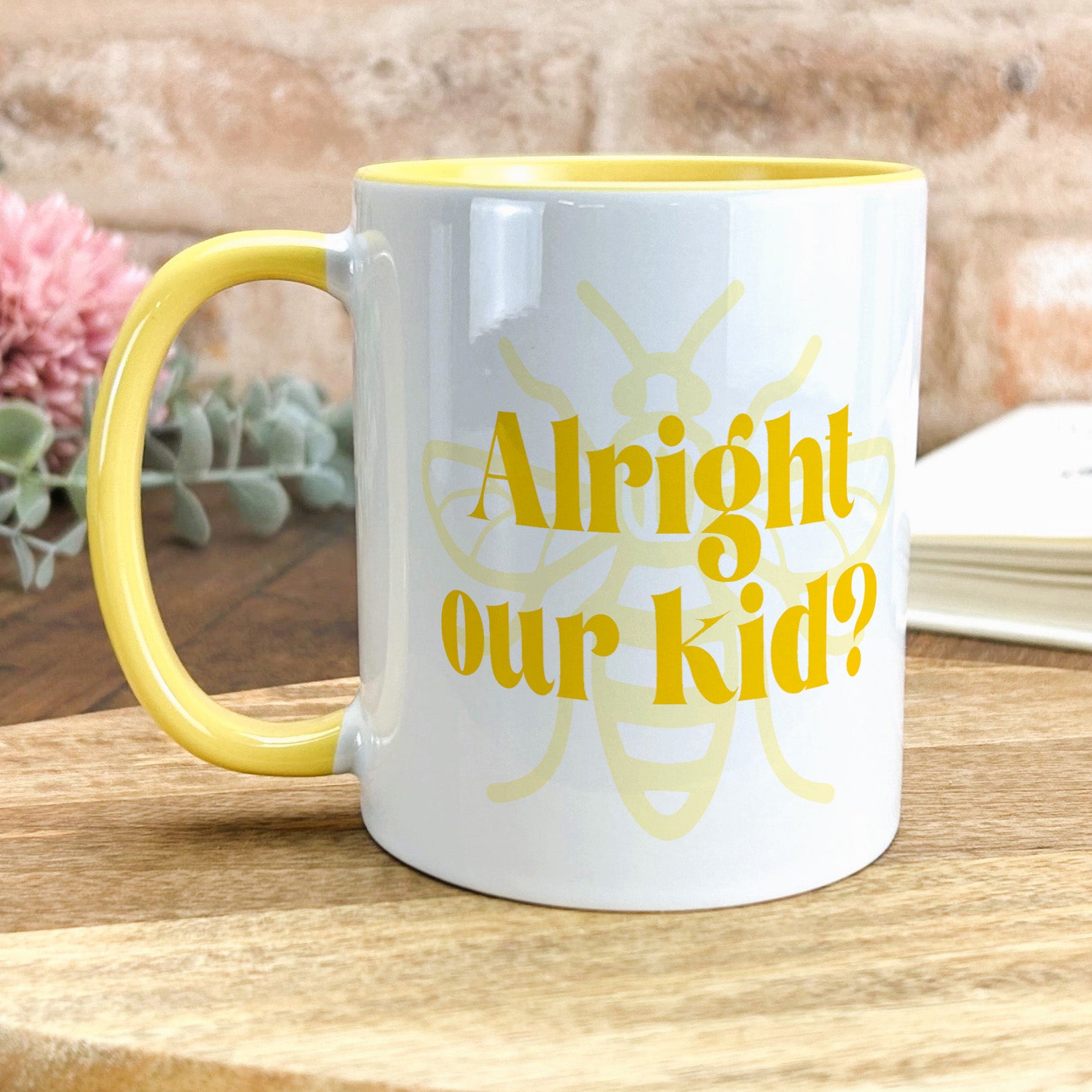 a yellow and white coffee mug sitting on top of a wooden table