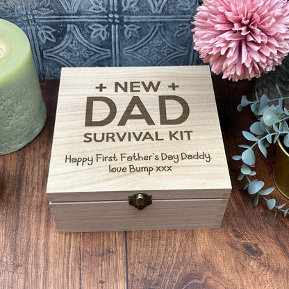 a new dad survival kit next to a candle and flowers