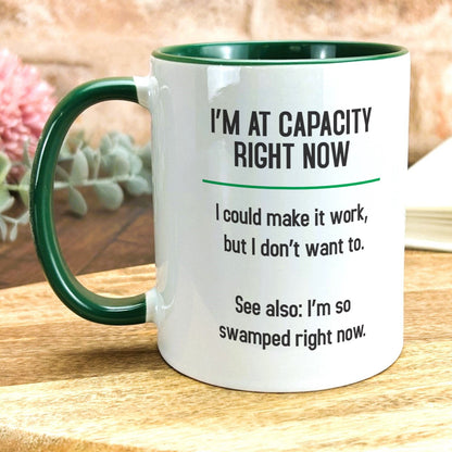 a green and white coffee mug sitting on top of a wooden table