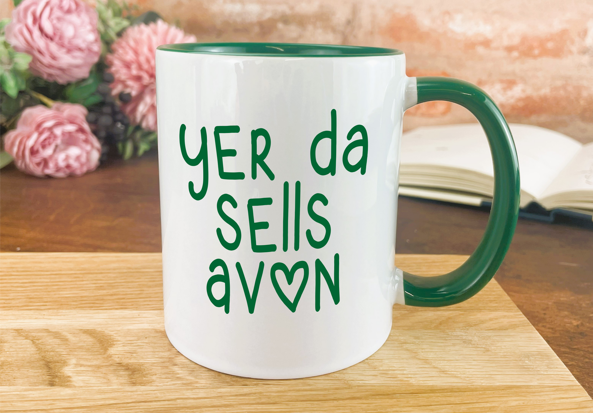 a green and white coffee mug sitting on top of a wooden table