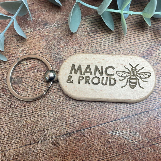 a wooden keychain with a picture of a bee on it