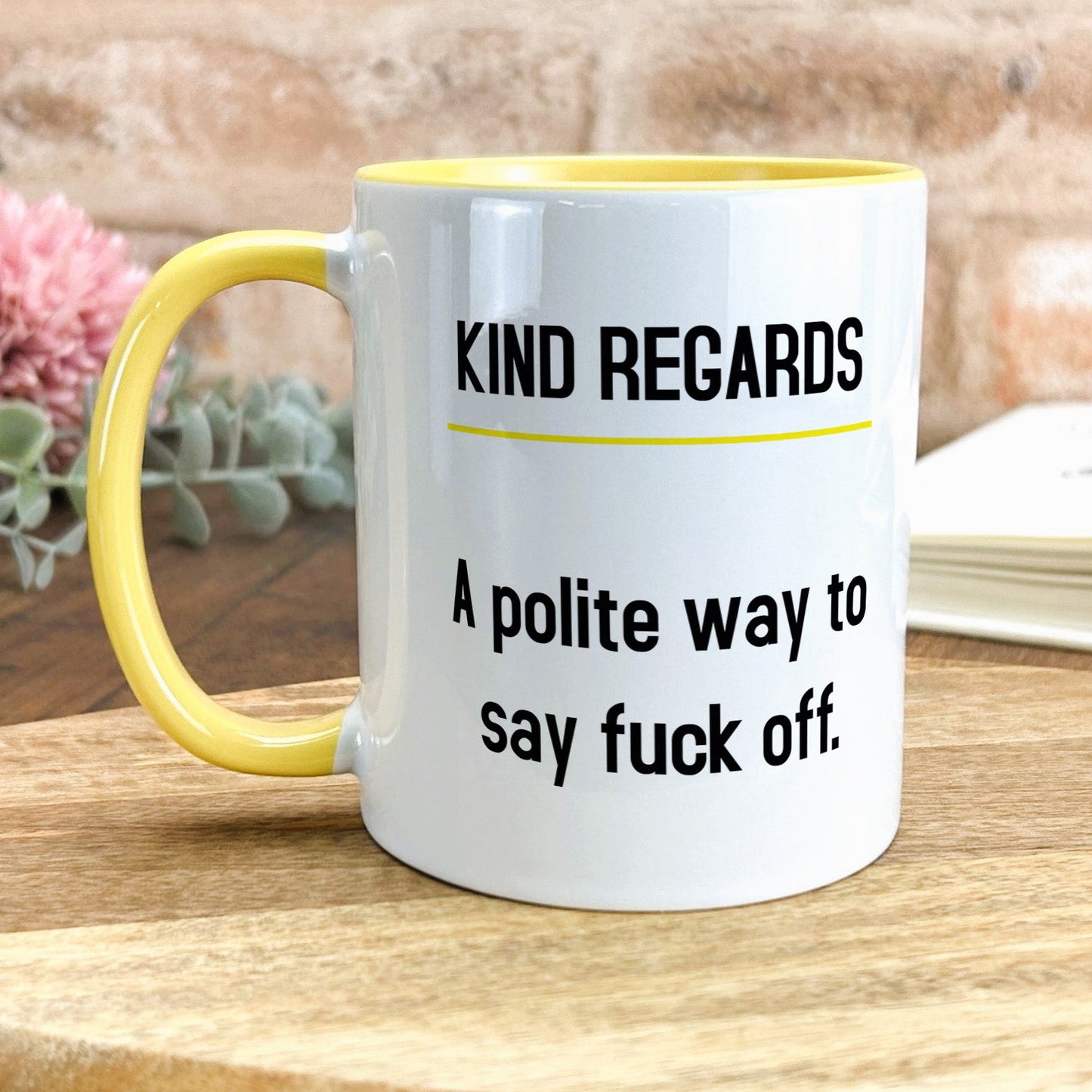 a yellow and white coffee mug sitting on top of a wooden table
