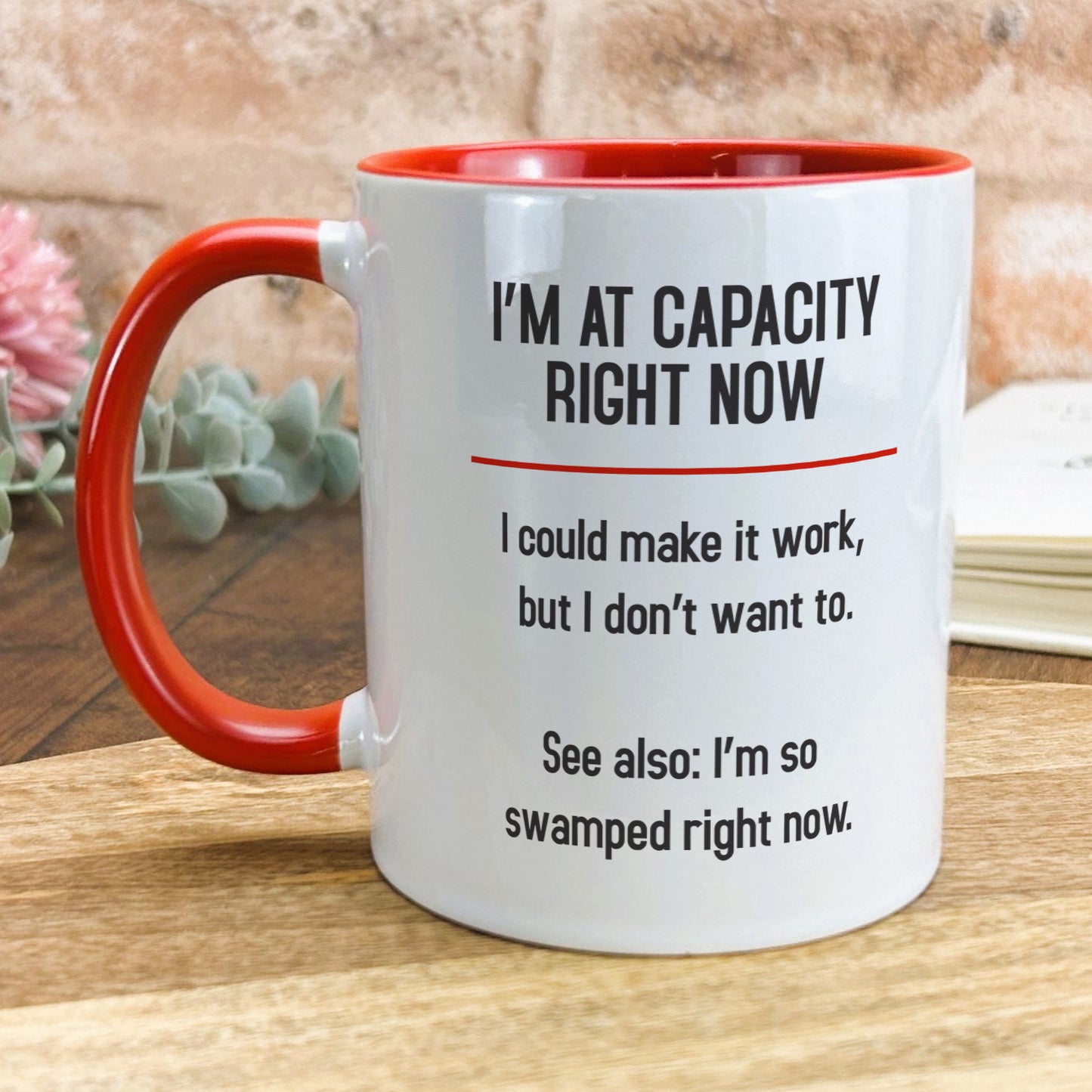 a red and white coffee mug sitting on top of a wooden table
