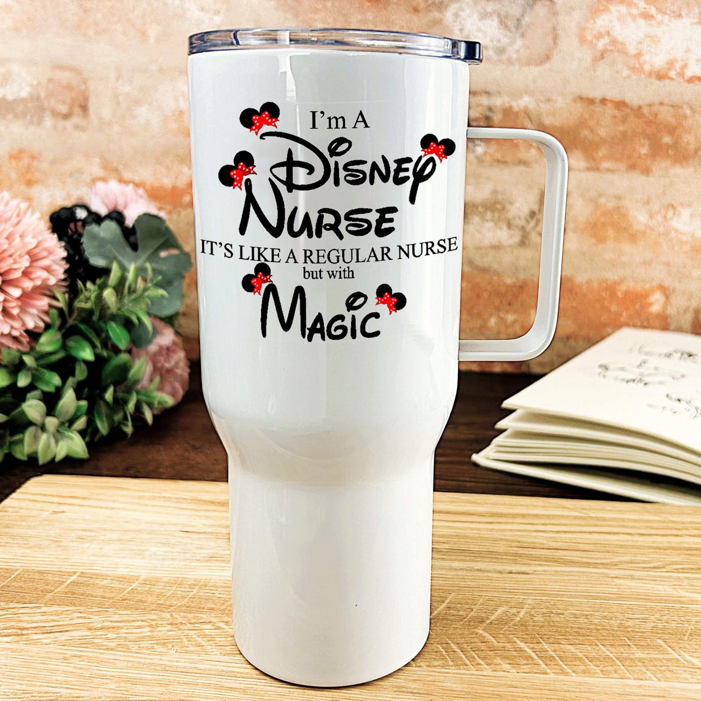 a white travel mug sitting on top of a wooden table