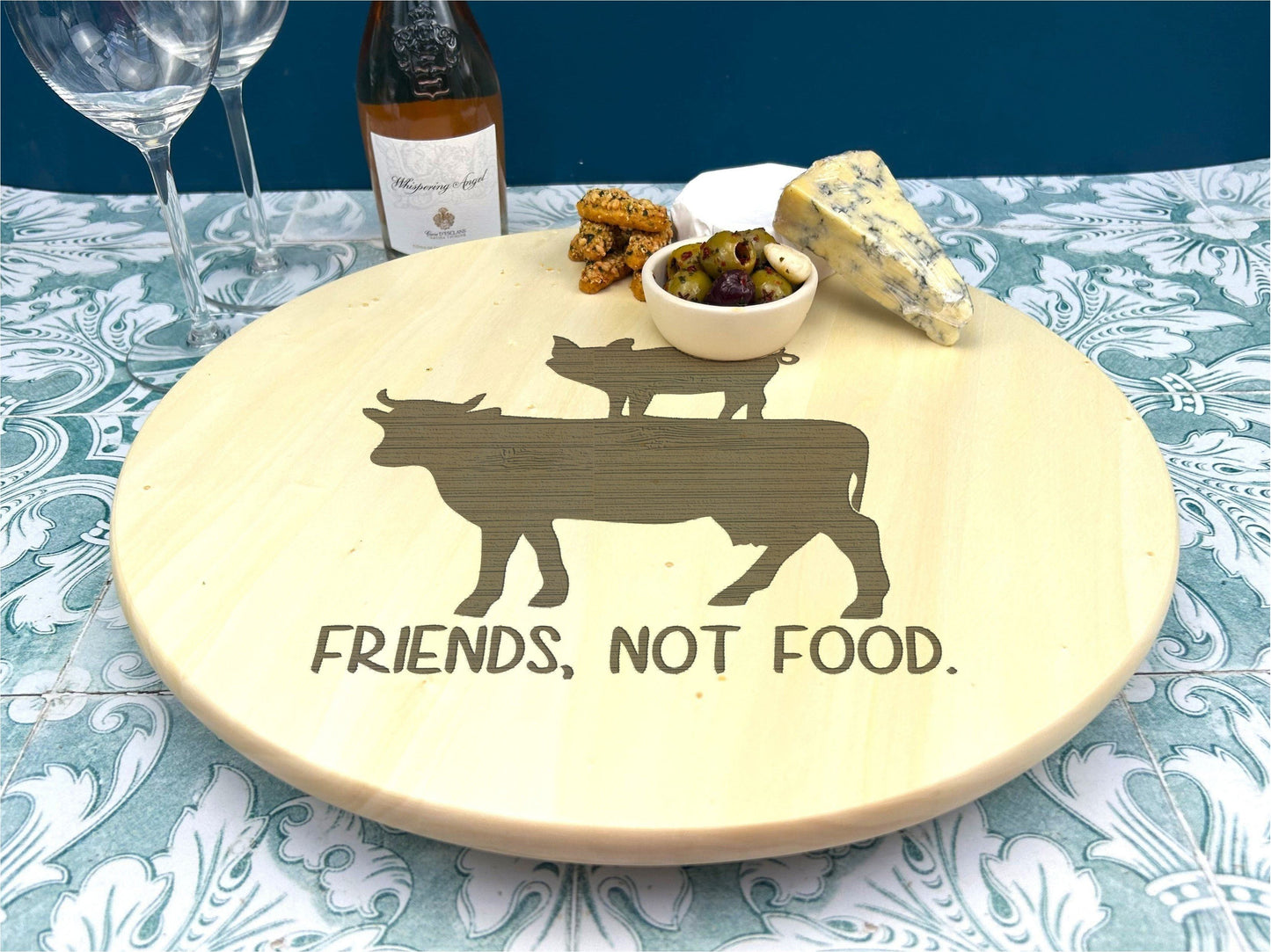 a wooden plate with a cow and a bowl of food on it