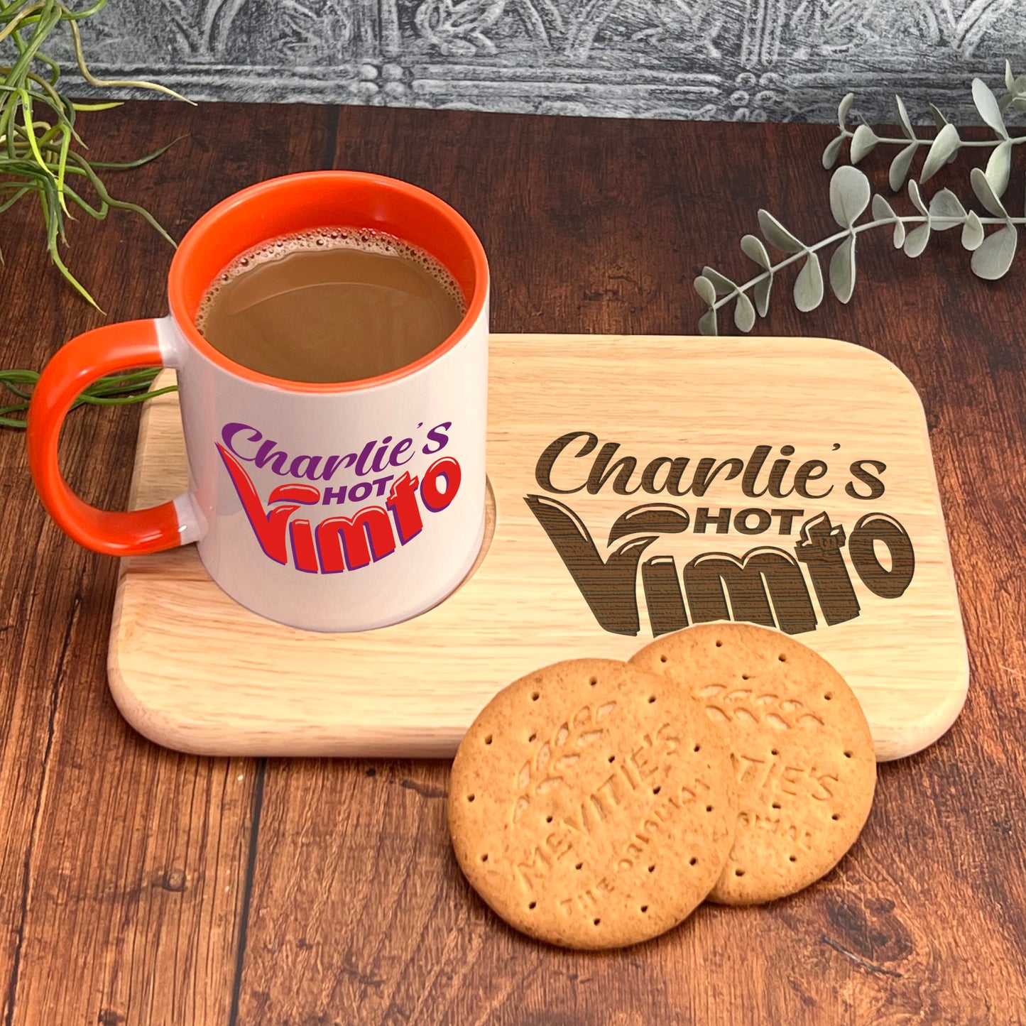 A mug of coffee and two cookies are placed on a wooden tray, with a plant in the background.