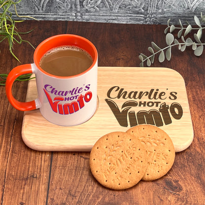 A mug of coffee and two cookies are placed on a wooden tray, with a plant in the background.