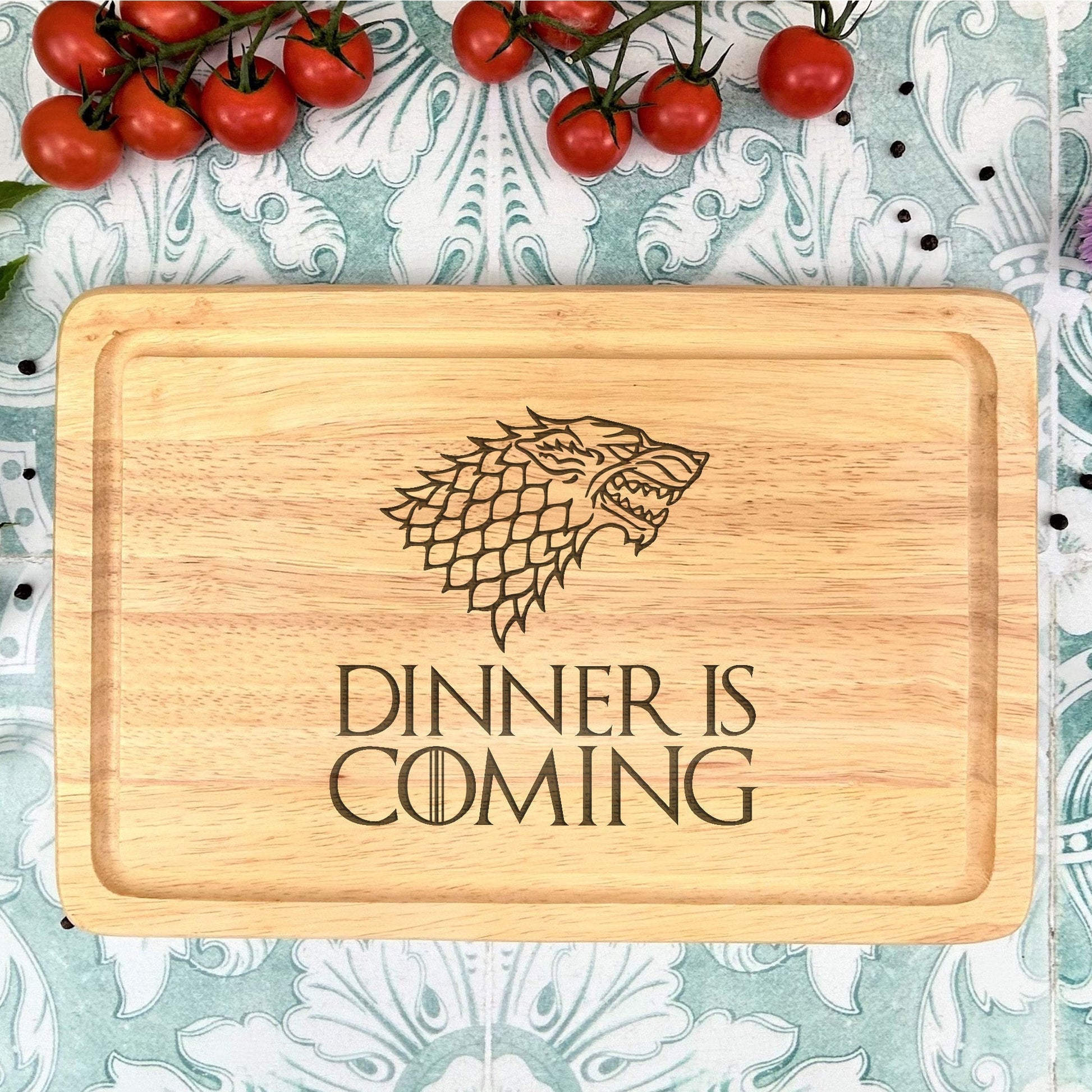 a wooden cutting board with a game of throne logo on it