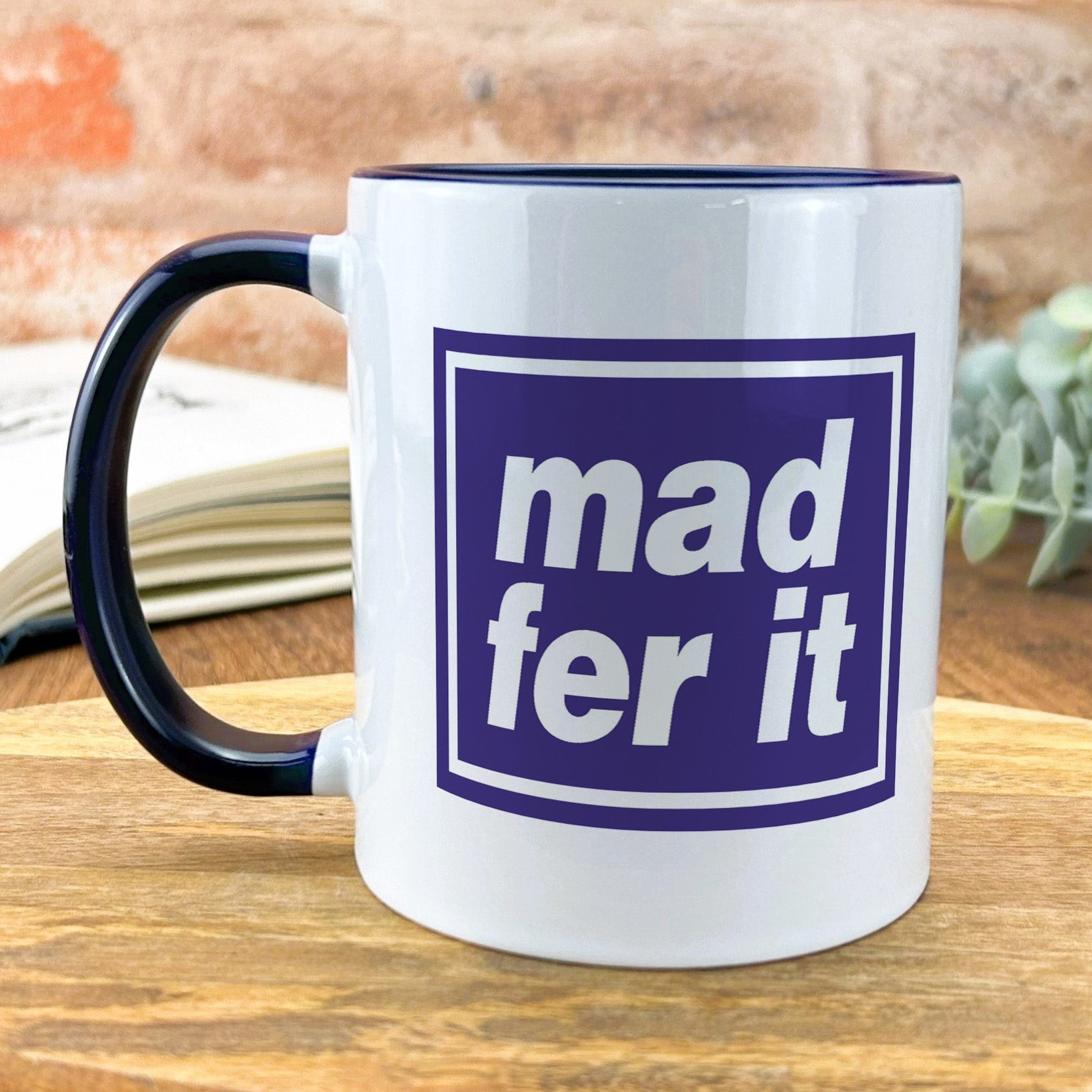 a white and blue mug sitting on top of a wooden table