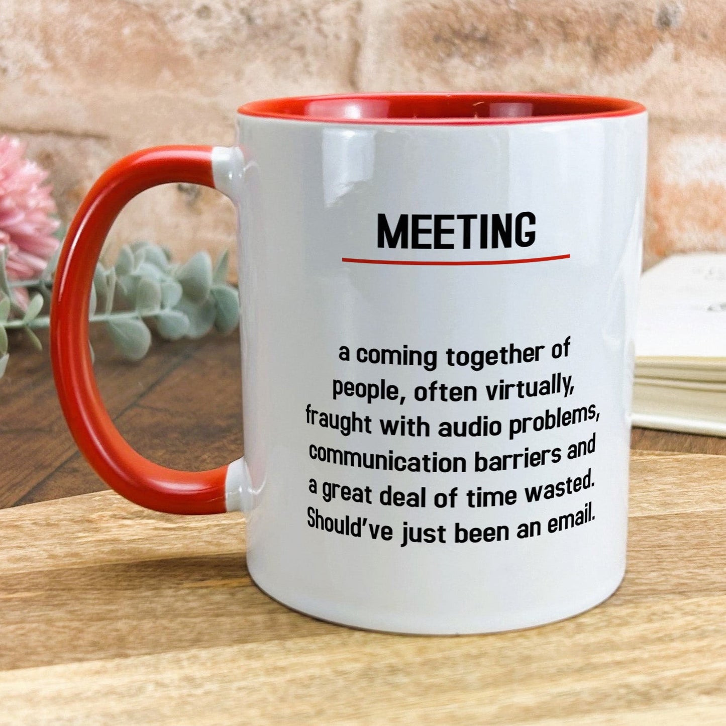 a red and white coffee mug sitting on top of a wooden table