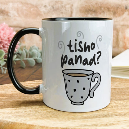 a black and white coffee mug sitting on top of a wooden table