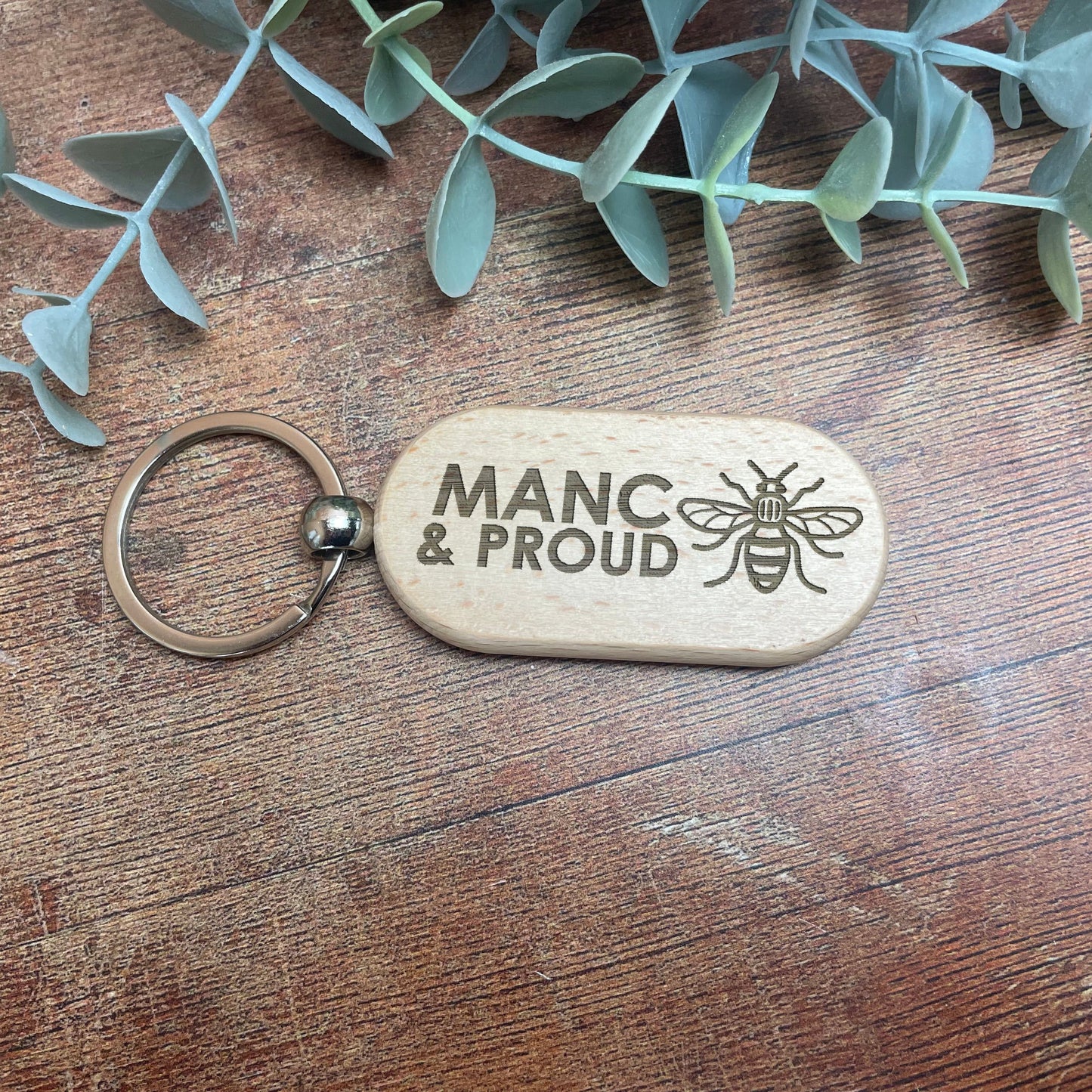 a wooden keychain with a picture of a bee on it