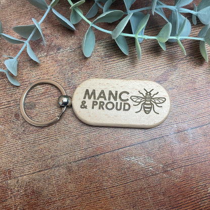 a wooden keychain with a picture of a bee on it