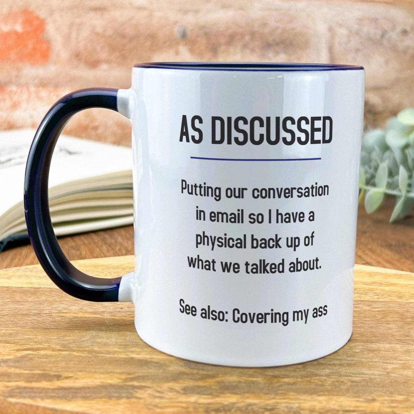 a white and black coffee mug sitting on top of a wooden table