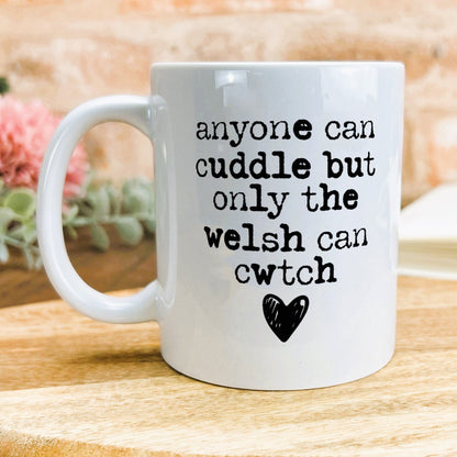 a white coffee mug sitting on top of a wooden table