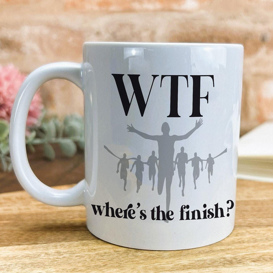 A white ceramic mug with a humorous text and graphic design printed on it.