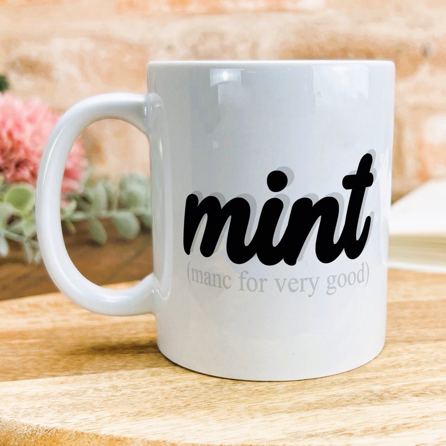 a white coffee mug sitting on top of a wooden table