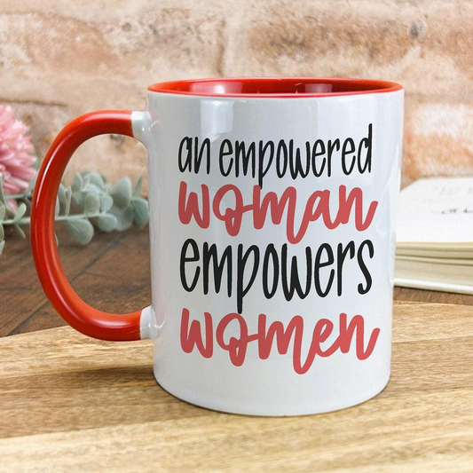 A white mug with a red handle, featuring the text "an empowered woman empowers women" printed on it.