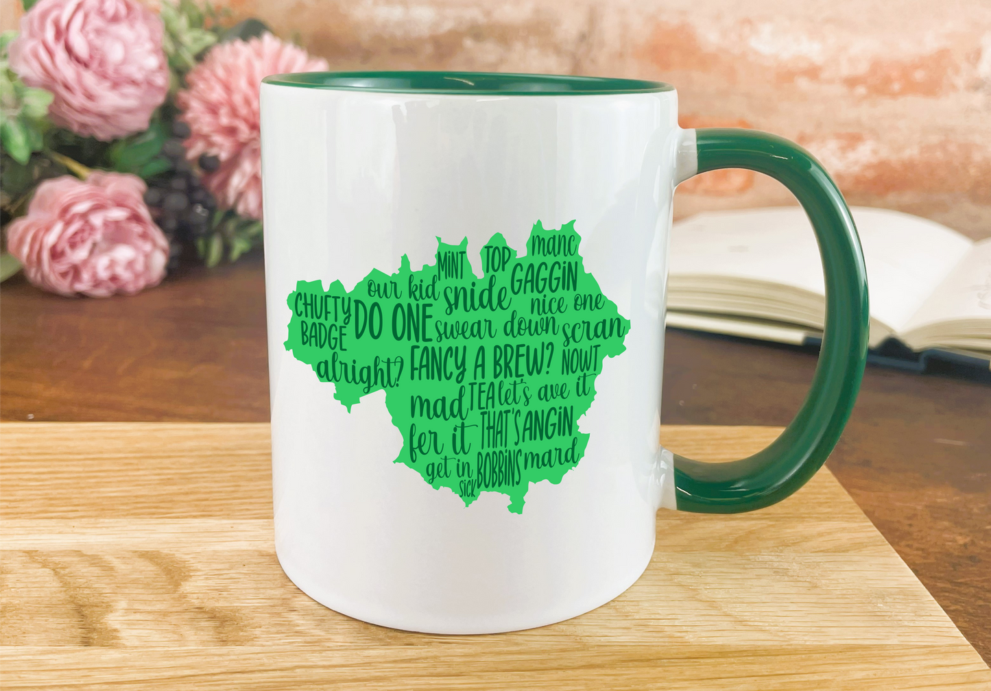 a green and white coffee mug sitting on a wooden table