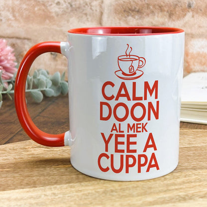 a red and white coffee mug sitting on top of a wooden table