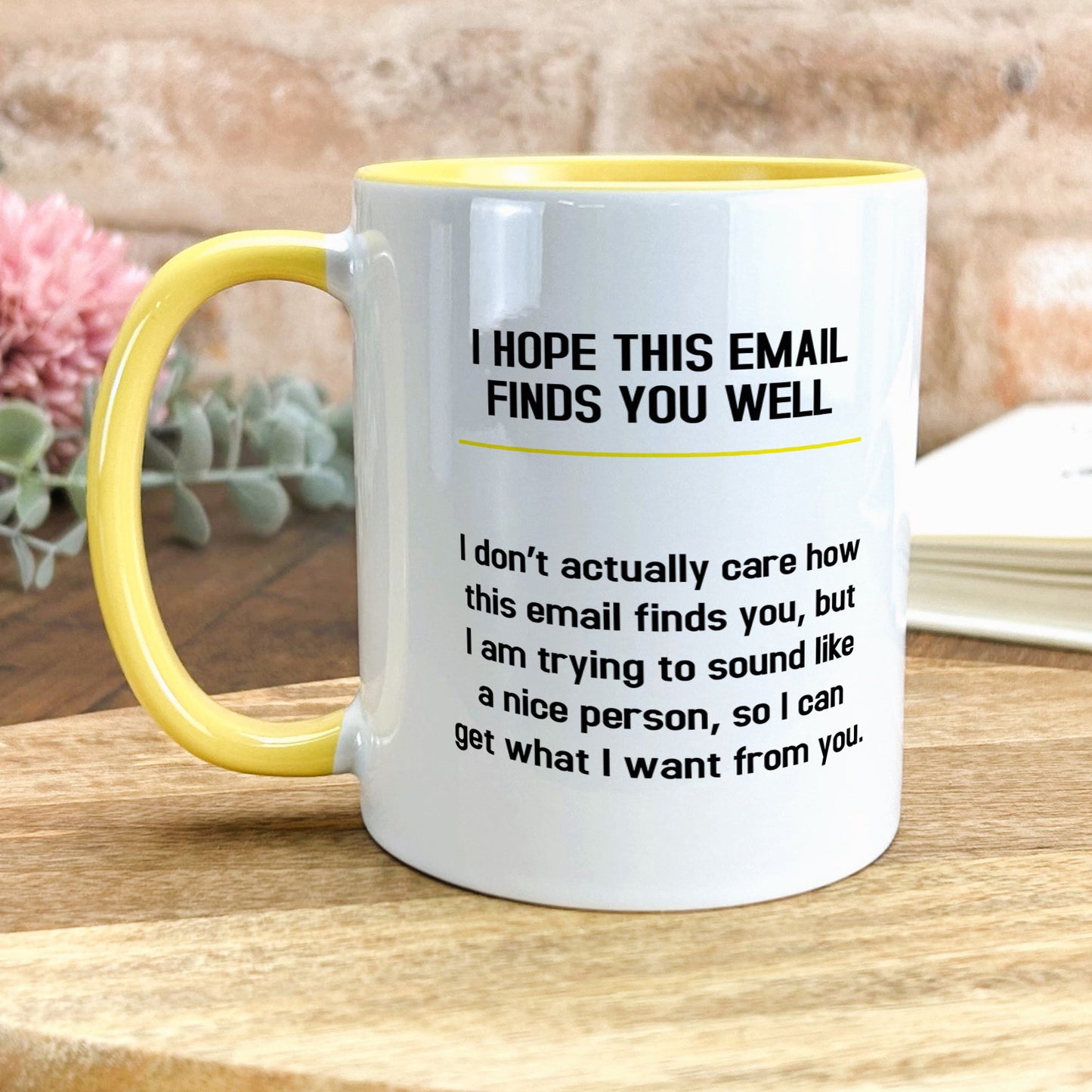 a yellow and white coffee mug sitting on top of a wooden table