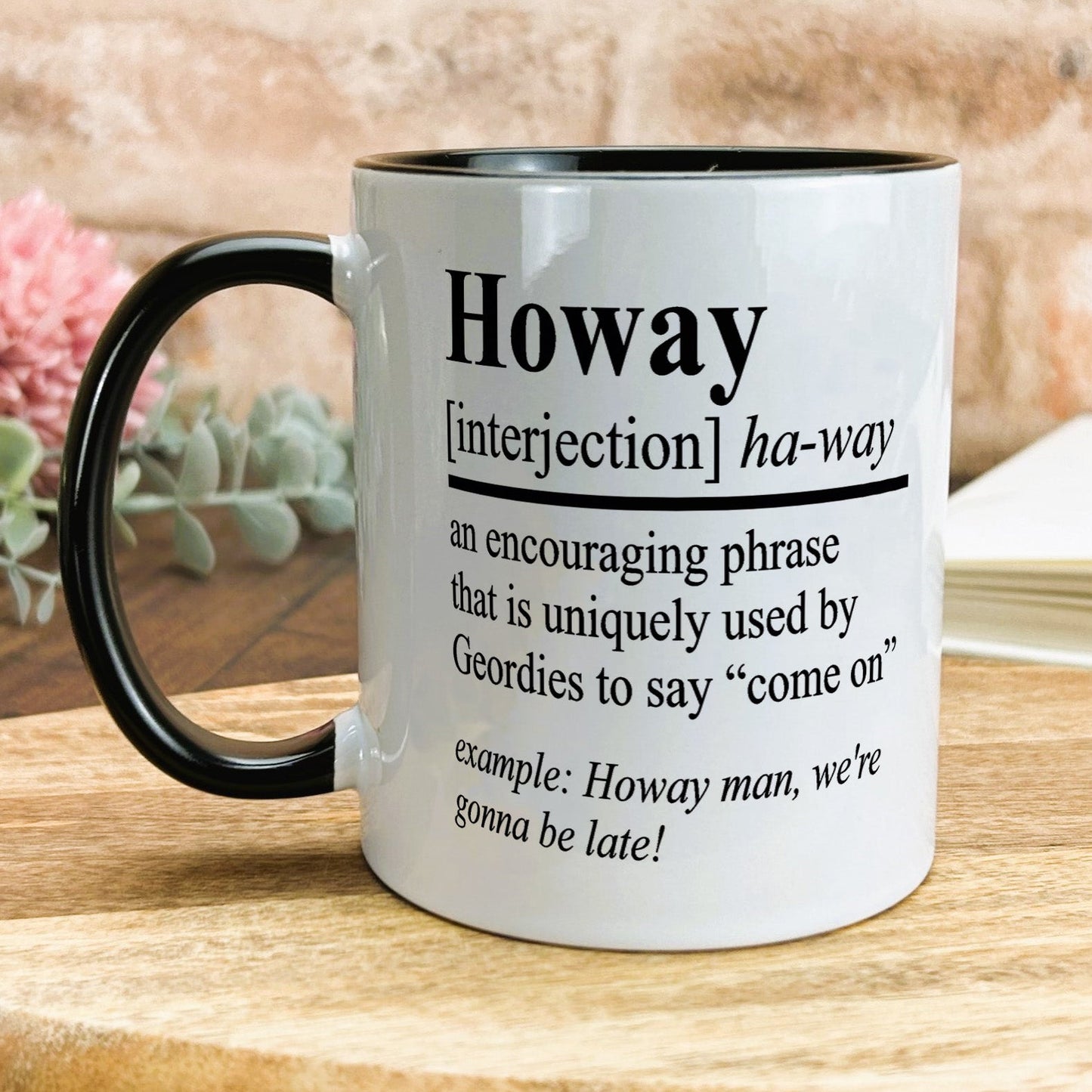 a black and white coffee mug on a wooden table