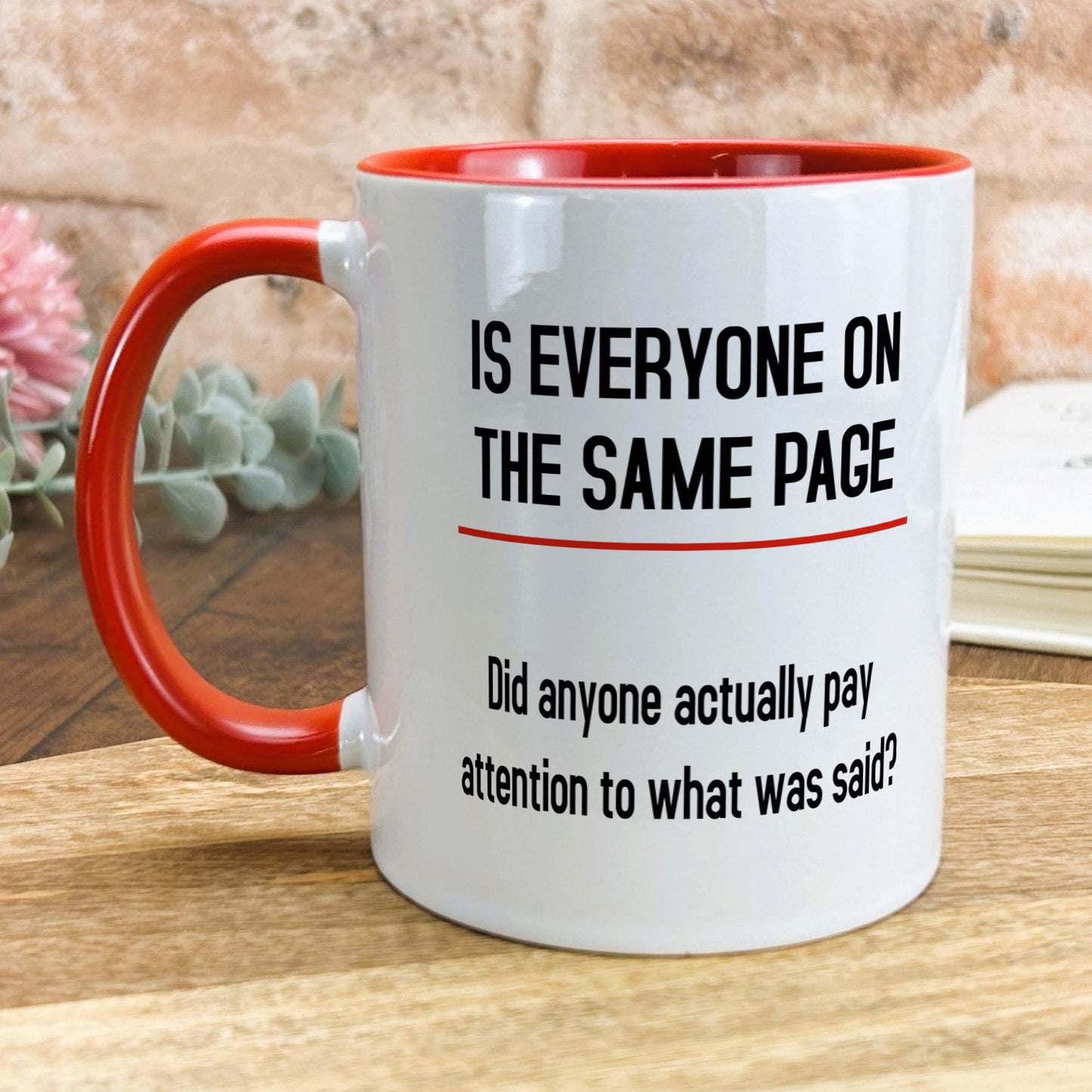 a red and white coffee mug sitting on top of a wooden table