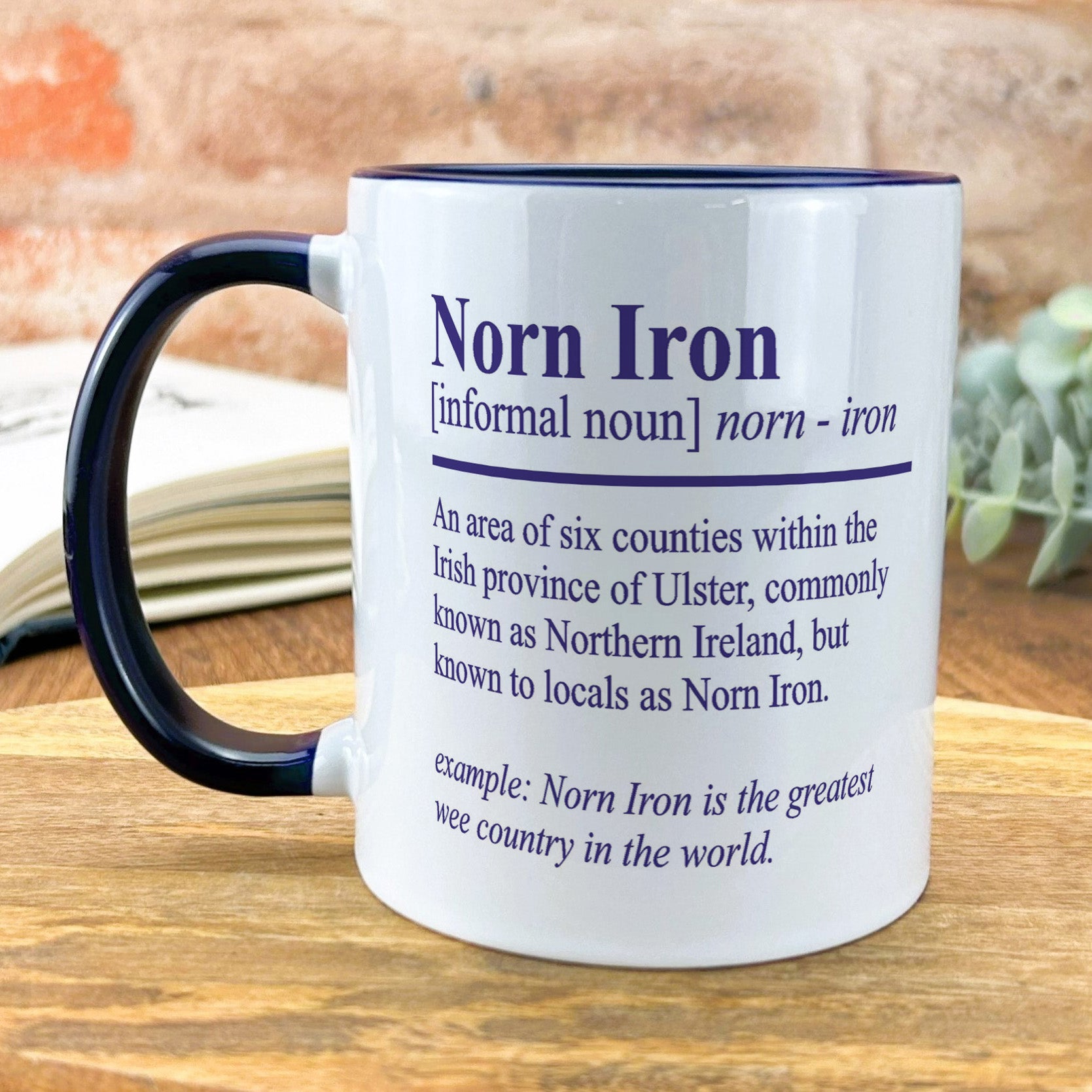 a black and white coffee mug sitting on top of a wooden table