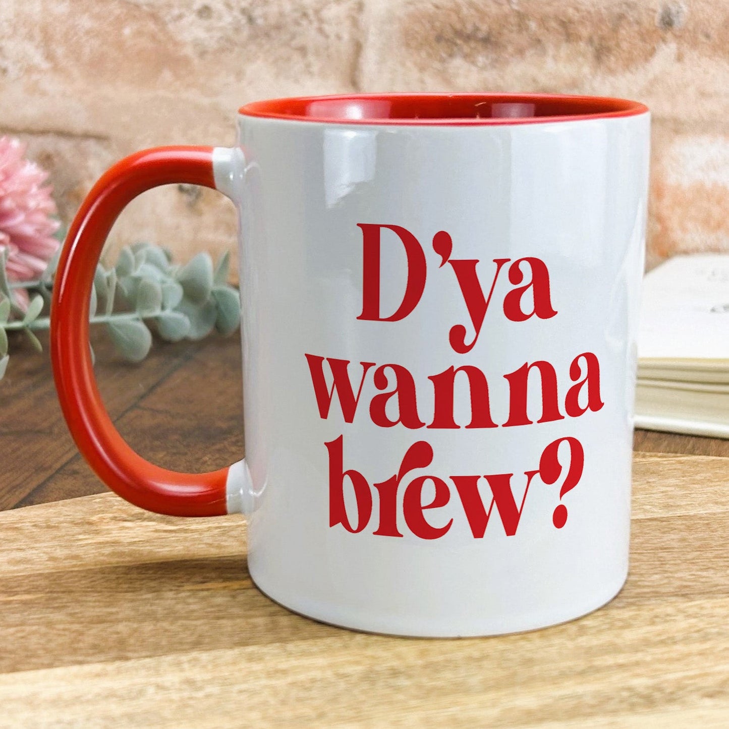 a red and white coffee mug sitting on top of a wooden table