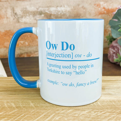 a blue and white coffee mug sitting on top of a wooden table
