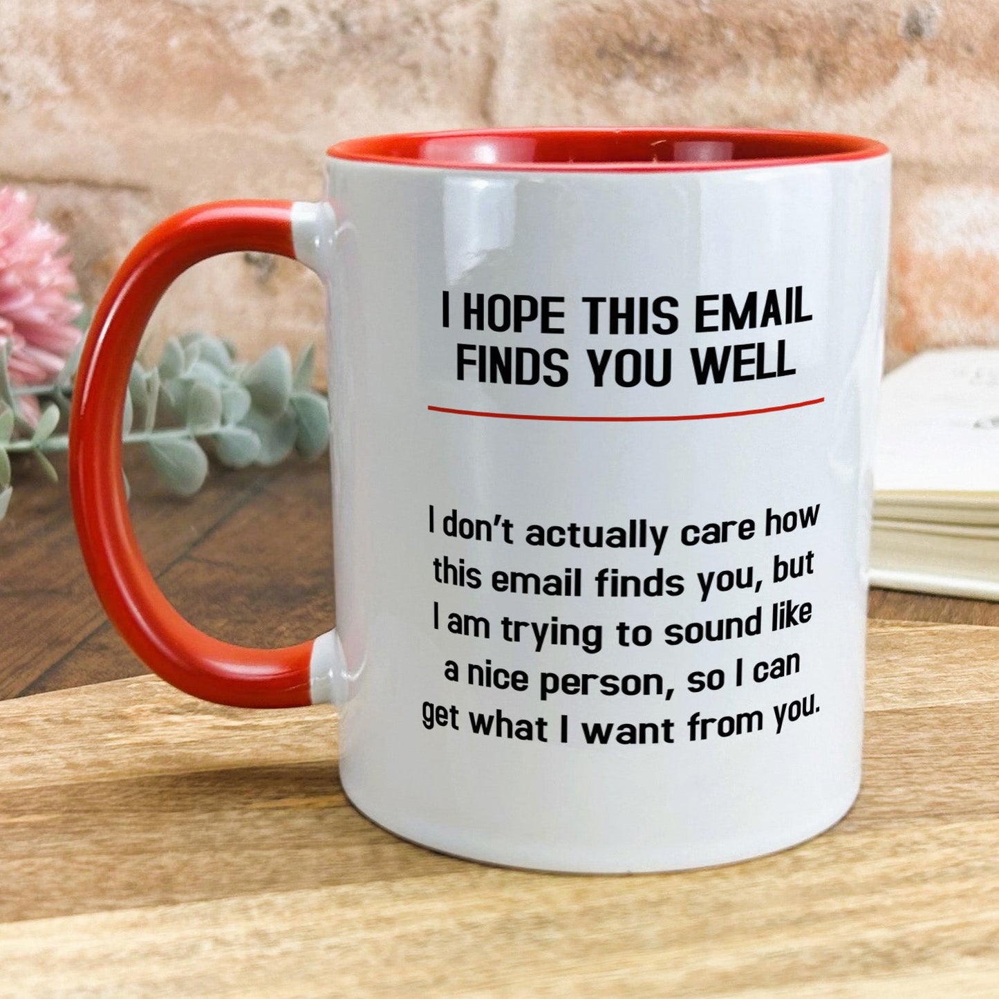 a red and white coffee mug sitting on top of a wooden table