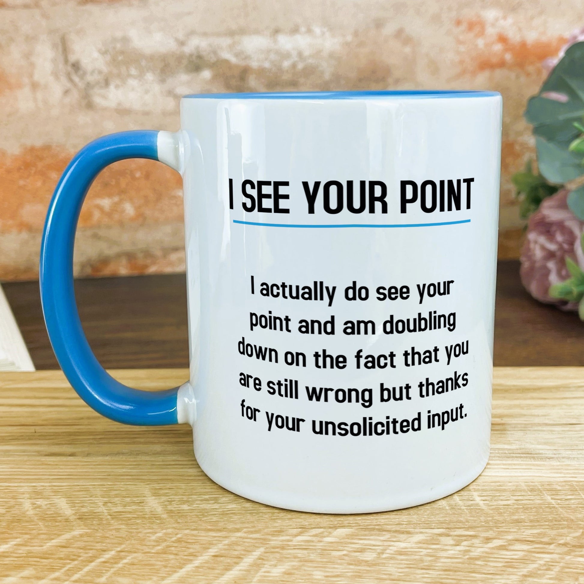 a blue and white coffee mug sitting on top of a wooden table