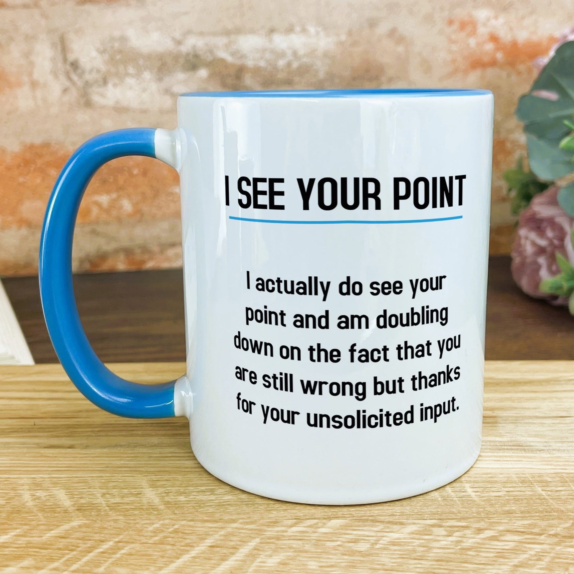a blue and white coffee mug sitting on top of a wooden table